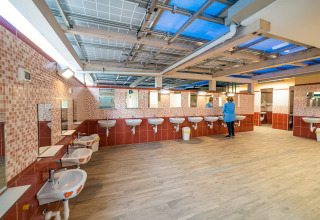 Bagno comune spazioso con lavandini e specchi, situato in un villaggio glamping per vacanze.