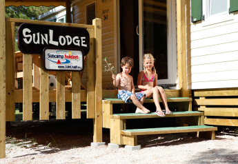 Due bambini seduti sulle scale della SunLodge Mobile Home Aspen al Camping Village Capo d'Orso in Italia.