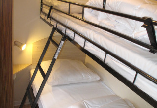 Literas con sábanas blancas y escalera en SunLodge Mobile Home Aspen, Camping Village Capo d'Orso, Italia.