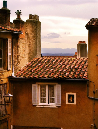 Foto de tejados de casas antiguas con vistas al mar, tomada en un parque vacacional de glamping.