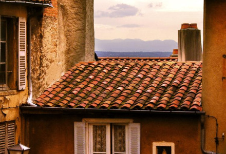 Foto de tejados de casas antiguas con vistas al mar, tomada en un parque vacacional de glamping.