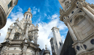 Torres históricas decorativas bajo cielo azul en un parque de vacaciones con alojamiento glamping.