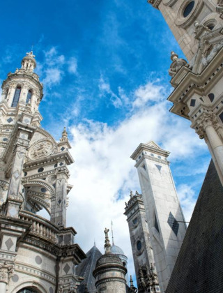 Torres históricas decorativas bajo cielo azul en un parque de vacaciones con alojamiento glamping.