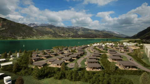 Alloggi glamping in un parco vacanze sui bordi di un lago, circondati da montagne e natura lussureggiante.