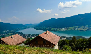 Vista panorámica de lago y montañas desde cabañas en un parque vacacional con alojamientos glamping.
