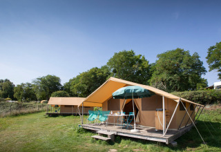 Luxe tenten en zithoek buiten op vakantiepark Huttopia Saumur, Pays de la Loire, Frankrijk.