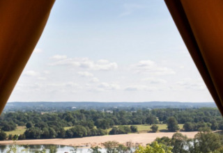 Frühstück vor einem Zelt mit Blick auf Fluss und Landschaft im Huttopia Saumur, Pays de la Loire, Frankreich.