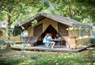 Vakantiegangers aan tafel voor een grote tent bij Huttopia Saumur, in Pays de la Loire, Frankrijk.