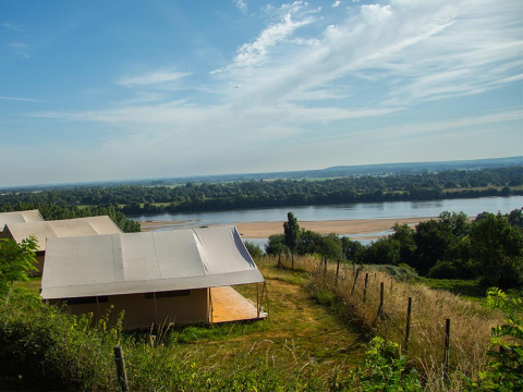 Blick auf Fluss und Landschaft von Zelten im Huttopia Saumur Ferienpark in Pays de la Loire, Frankreich.
