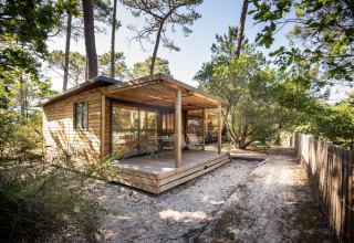 Cabaña de madera en Chalet Evasion con terraza, rodeada de naturaleza, ideal para una experiencia glamping.