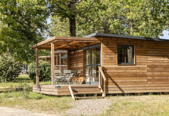 Chalets en bois entourés d’arbres au Chalet Evasion, hébergement glamping parfait pour un séjour nature.