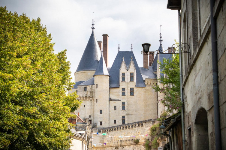 View of a historic castle with towers and stone walls from a street in Centre-Val de Loire, France.