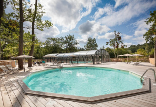 Udendørs swimmingpool med træterrasse og liggestole på Village Huttopia Lac de Rillé, Centre-Val de Loire.