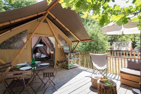 Canadienne safari tent at Village Huttopia Lac de Rillé, France, featuring a cozy furnished wooden terrace.