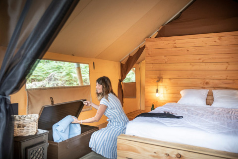 Kvinde i safari-teltet Tente Trappeur Duo Village på Village Huttopia Lac de Rillé, Frankrig.
