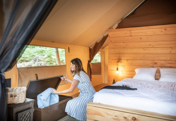Donna nella tenda safari Tente Trappeur Duo Village al Village Huttopia Lac de Rillé, Francia.