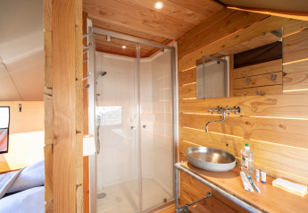 Interno bagno e doccia della tenda safari Tente Trappeur Duo Village presso Huttopia Lac de Rillé, Francia.