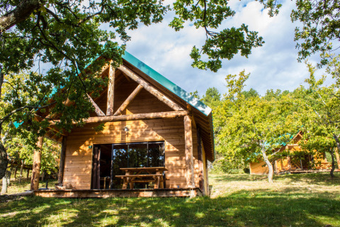 Cabañas de madera entre árboles en el Village Huttopia Dieulefit, un parque vacacional en Auvergne-Rhône-Alpes.