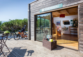 Fietsen, tafels en sportmateriaal aan het Bureau des Guides bij Village Huttopia Dieulefit, Auvergne-Rhône-Alpes, Frankrijk.