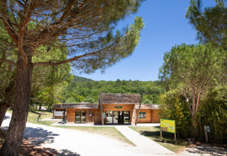 Toegang tot vakantiepark Village Huttopia Dieulefit in Auvergne-Rhône-Alpes, Frankrijk, tussen dennen.
