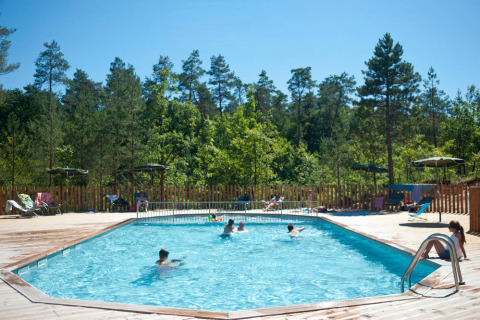 Piscina al aire libre con huéspedes disfrutando en Village Huttopia Lanmary, parque vacacional en Nouvelle-Aquitaine, Francia.