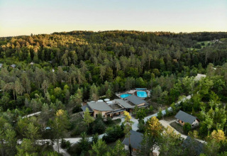Vue aérienne du Village Huttopia Lanmary, parc de vacances en Nouvelle-Aquitaine, France, entouré de forêt.
