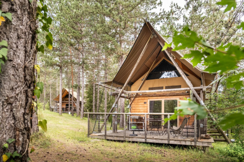 Cabañas de madera entre pinos en Village Huttopia Lanmary, un parque vacacional en Nouvelle-Aquitaine, Francia.