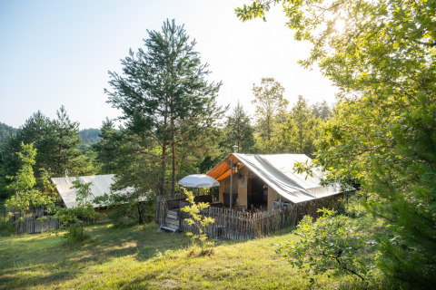 Tiendas de glamping entre árboles verdes en el parque vacacional Huttopia Lanmary, Nouvelle-Aquitaine, Francia.