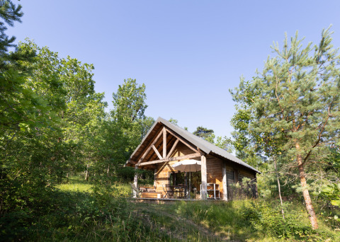 Houten chalet tussen de bomen bij Village Huttopia Lanmary vakantiepark, Nouvelle-Aquitaine, Frankrijk