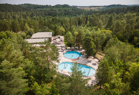 Aerial view of Village Huttopia Lanmary holiday park with two pools set amongst forest in Nouvelle-Aquitaine.