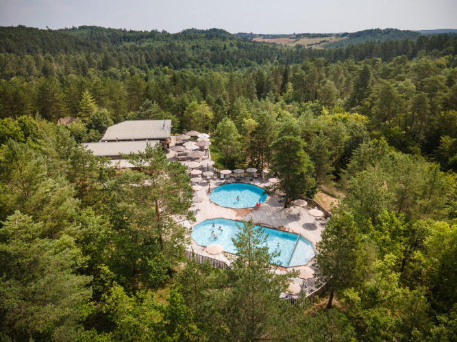 Vue aérienne du Village Huttopia Lanmary avec deux piscines entourées de forêt en Nouvelle-Aquitaine, France.