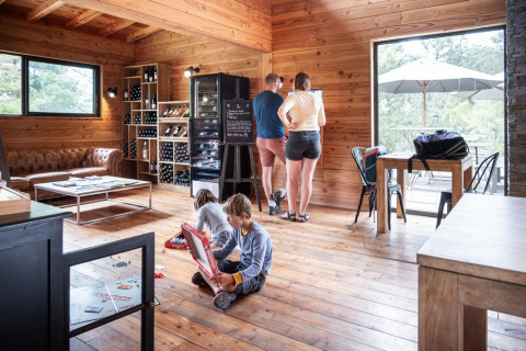 Gezin geniet in een houten hut bij Village Huttopia Lanmary, vakantiepark in Nouvelle-Aquitaine, Frankrijk.