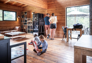 Famiglia che si rilassa in una cabina di legno al Village Huttopia Lanmary, Nouvelle-Aquitaine, Francia.