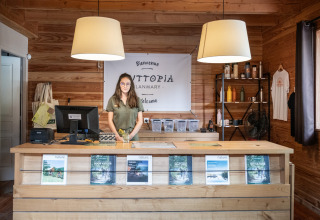 Receptionen hos Village Huttopia Lanmary i Nouvelle-Aquitaine, Frankrig, med medarbejder bag skranken.