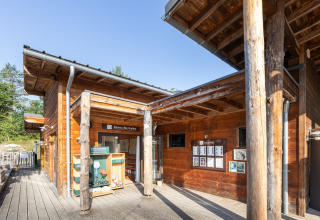 Wooden lodge at Village Huttopia Lanmary holiday park in Nouvelle-Aquitaine, France, under clear sky.