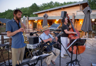 Jazzband optræder udendørs ved Village Huttopia Sud-Ardèche feriepark i Auvergne-Rhône-Alpes, Frankrig.
