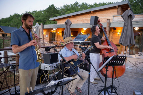 Banda de jazz tocando en vivo en la terraza de Village Huttopia Sud-Ardèche en Auvergne-Rhône-Alpes, Francia.