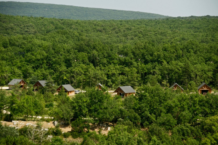 Cabanes en bois nichées dans la forêt au Village Huttopia Sud-Ardèche, Auvergne-Rhône-Alpes, France.
