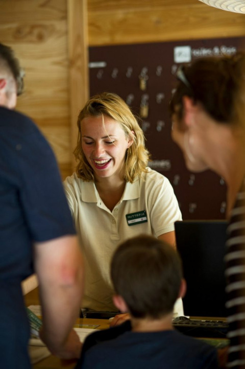 Receptioniste ontvangt en helpt gasten in Village Huttopia Sud-Ardèche, Auvergne-Rhône-Alpes, Frankrijk.