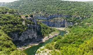 Scenic view of lush cliffs and a winding river near Vagnas in Auvergne-Rhône-Alpes, France.