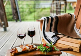 Outdoor photo of food and wine on a tree stump at Village Huttopia Sud-Ardèche, Auvergne-Rhône-Alpes, France.