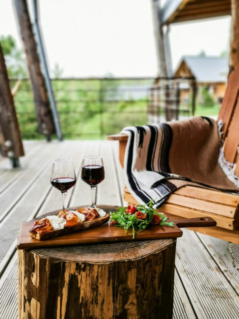 Foto all’aperto di cibo e vino su un tronco a Village Huttopia Sud-Ardèche, Auvergne-Rhône-Alpes, Francia.