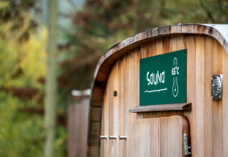 Holzsauna mit Schild, das 65°C anzeigt, im Feriendorf Huttopia Sud-Ardèche im französischen Auvergne.