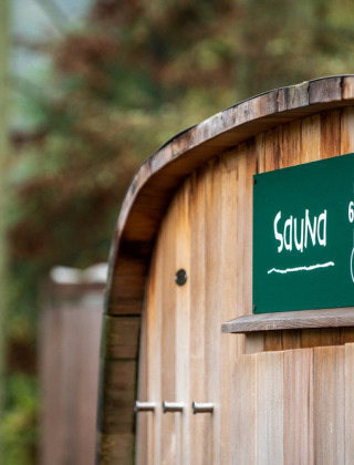 Holzsauna mit Schild, das 65°C anzeigt, im Feriendorf Huttopia Sud-Ardèche im französischen Auvergne.