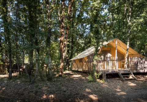 Cabaña tipo tienda safari en los bosques de Village Huttopia Sud-Ardèche, parque vacacional en Auvernia-Ródano-Alpes.