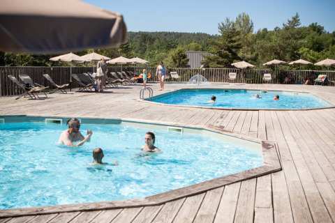 Huéspedes disfrutan de dos piscinas exteriores con tumbonas y sombrillas en el soleado Sud-Ardèche.