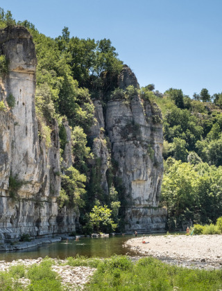 Rock formations and river scenery near Vagnas, Auvergne-Rhône-Alpes, France, with lush trees and clear sky.