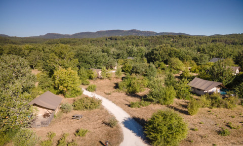Panorama von Village Huttopia Sud-Ardèche mit Zelten, Wegen und grüner Landschaft in Auvergne-Rhône-Alpes.