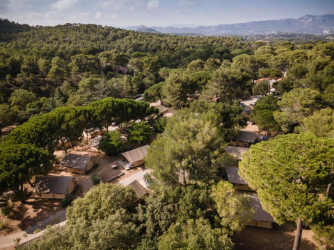 Vista aérea de una zona boscosa con tiendas de campaña y montañas cerca de La Seyne-sur-Mer, Provenza, Francia.