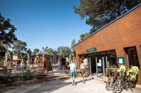 Parque vacacional Huttopia La Forêt de Janas en Provenza-Alpes-Costa Azul, con huéspedes y bicicletas afuera.